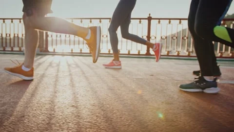 Group of people practicing morning jog workout on sports path in morning, close Stock Footage