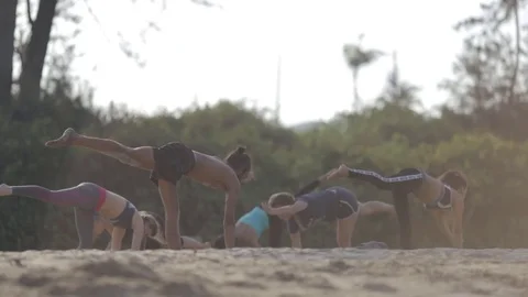 Group of people practicing yoga on the beach Stock Footage 73918006