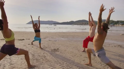 Group of people practicing yoga on the beach Stock Footage 74779204