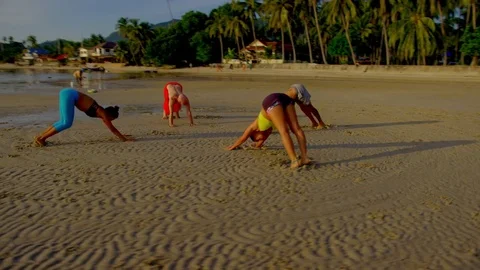 Group of people practicing yoga on beach at sunset Stock Footage 75290327