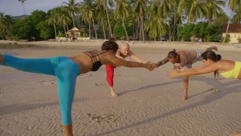 Group of people practicing yoga on beach during sunset Stock Footage 75291571