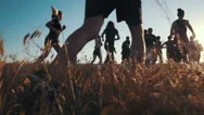 Group Of People Running On A Field In Sunset, Slow Motion Stock Footage