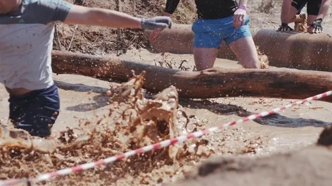 A group of people running through mud pit in obstacle endurance race Stock Footage 75261715