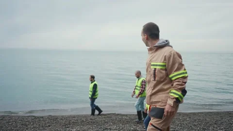 A group of people searching for a missing person on the beach by the water or Stock Footage 235536039