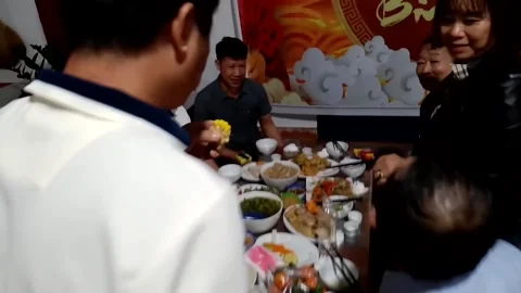 A group of people singing and dancing during a family reunion meal Stock Footage 327270781