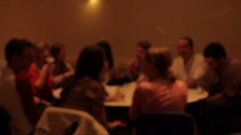 Group of people sit around table in function hall talking and laughing Stock Footage 107628554