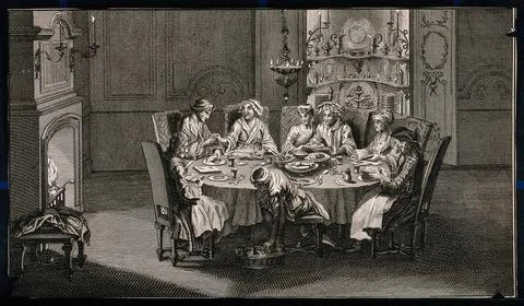 A group of people sit around a table sharing a meal and a person in a turba.. Ilustración de archivo