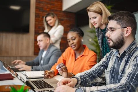 Group of People Sitting at a Table With Laptops Foto stock