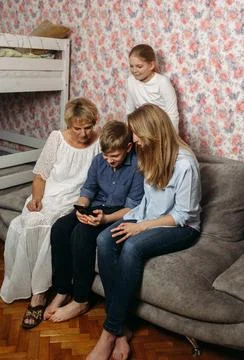Group of People Sitting on Top of a Couch Stock Photos