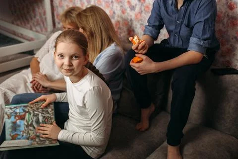 Group of People Sitting on Top of a Couch Stock Photos