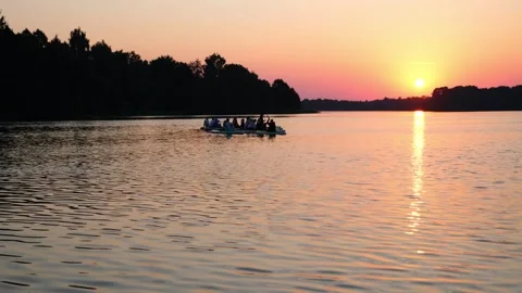Group of people on stand up paddle board gliding across lake at sunset. Stock Footage 340356891
