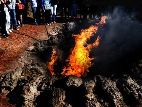 Group of people standing around a fire in a volcanic crater, Lanzarote, Canary Stock Photos