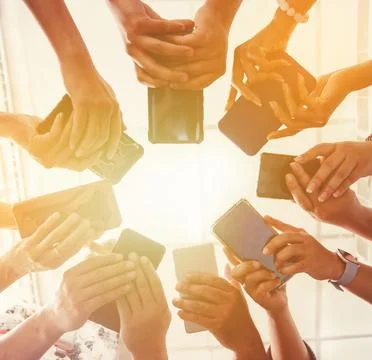 Group Of People Standing In Circle Using Smartphone Stock Photos