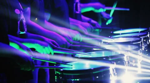 A group of people synchronously hit the percussion in the rays of light. Stock Footage 61488538