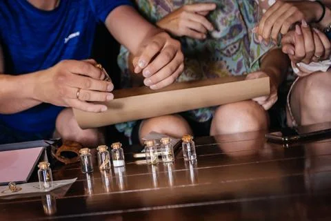 A group of people at a table solves riddles on parchment. Stock Photos