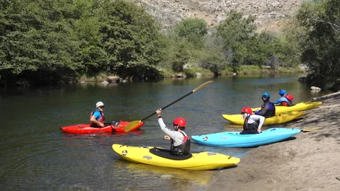 A group of people take part in a guided river kayaking class Stock Footage 133143584