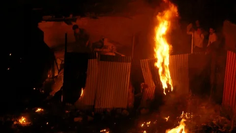 Group of people trying to extinguish fire in the house at night using cloths Stock Footage 112234445