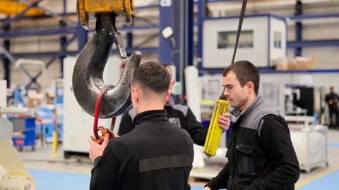 Group of people using crane in a factory Stock Footage 262604600