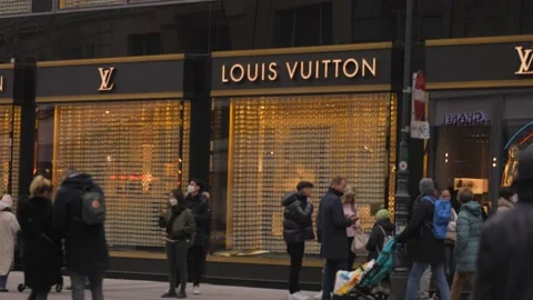 Group Of People Waiting in row to get into Louis Vuitton store in Vienna Stock Footage 165354520