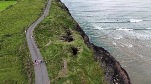 A group of people walking along the rugged coastline at Fairy Bridges, Ireland. Stock Footage 342716002