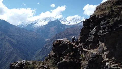 Group of people walking over High Rocky Mountain pass snowy mountains background Vídeo Stock 205599352