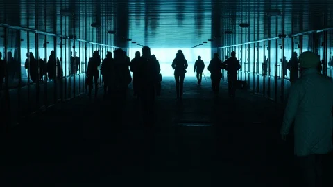 A group of people is walking through a black and blue underground passage. Stock Footage 111511297