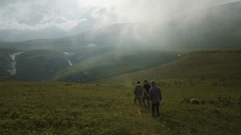 A group of people walking through mountain meadows Видео 112735086