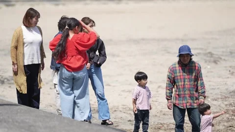 Group of people walks together on dry, sandy ground Video stock 339980908
