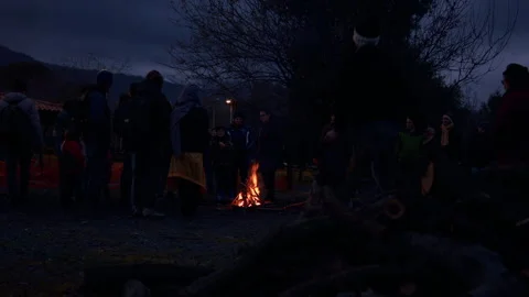 Group of people warming up around a campfire Stock Footage 168183550
