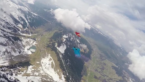 Group of people in wingsuits flying high above ground with clouds around, Aspen Stock Footage 129131966