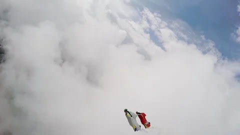 Group of people in wingsuits flying through clouds high above ground, Aspen Stock Footage 129132082