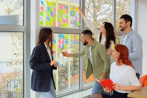Group of people working with business plan at Kanban board on window in offic Stock Photos