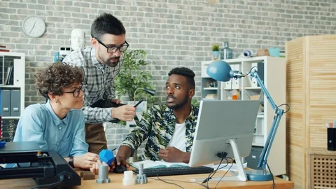 Group of people working in office using 3d printer, tablet and computer talking Stock Footage 119564760