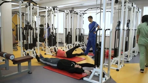 A group of people working out on training apparatus with instructors at gym. HD Stock-Footage 73079505