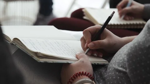 A group of people is writing in a notebook Stock Footage 105484003