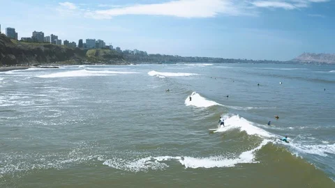 Group of Peruvian surfers catching waves at Makaha beach in Miraflores Stock Footage 105369089