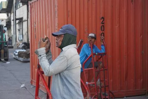 Group of port worker pile up goods to the ship Фото