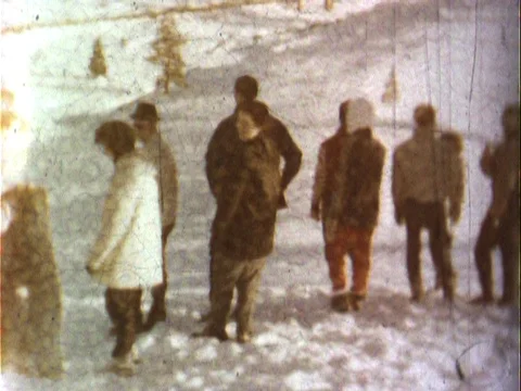 Group preparing to sled down a snowy hill - vintage 8mm Stock Footage 79174710
