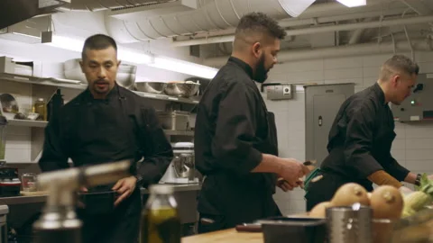 Group of professional chefs setting up at their stations at a long counter in in Stock Footage 199458758