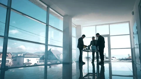 A group of professional men work together at a table in a technological office Video stock 105159965