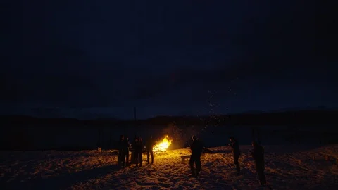 Group of professional skiers making up fire outside and having fun around it Stock Footage 129110169