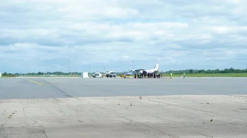 Group of professional skydivers moving into the white aircraft before it Stock Footage 159780205