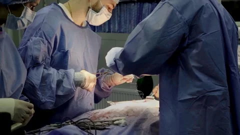 A group of professional surgeons in uniform perform an operation Stockbeeldmateriaal 269440400