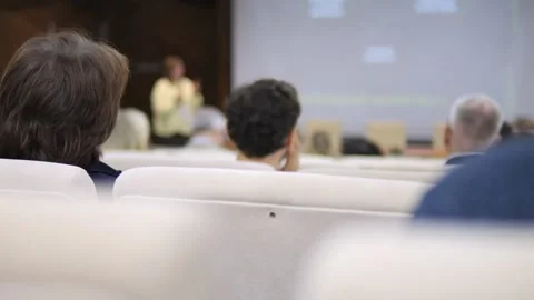 Group of professionals attentively watches presentation in conference room Stock Footage 346173729