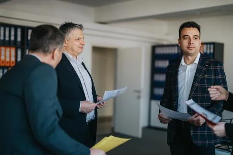 Group of professionals discussing documents in a modern office meeting room 스톡 사진