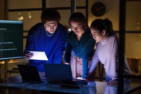 Group of Programmers Solving Problem In Evening Foto stock