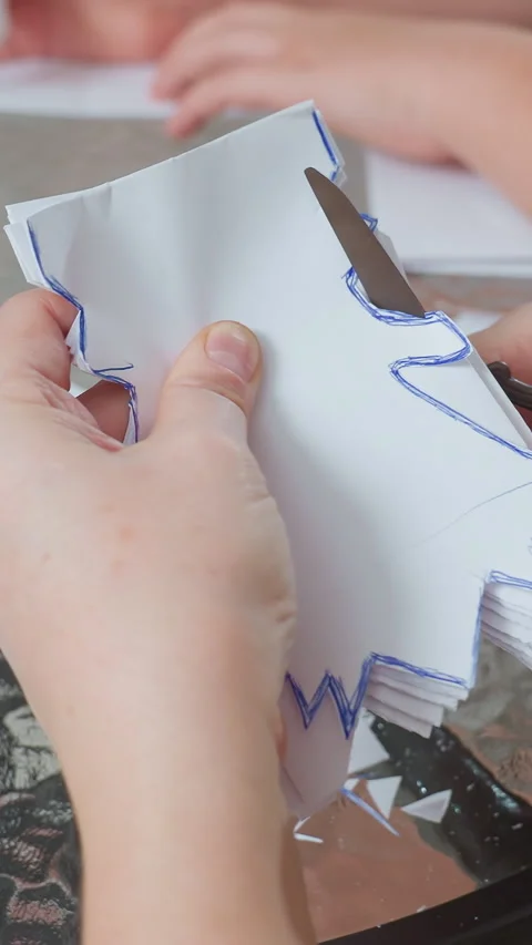 Group project making layered paper snowflakes during holidays, Engaged children Stock Footage 326823548