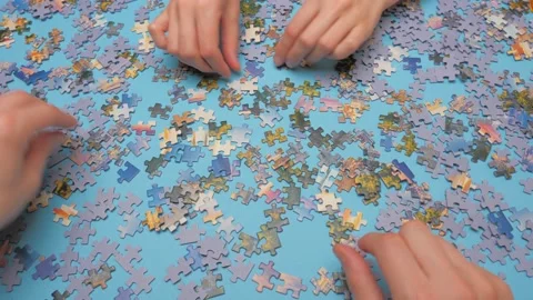 A group of puzzles, hands on a blue surface background. Puzzle game, Preschool Stock Footage 132928977