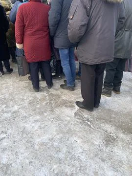 A group, a queue of people with handcarts in the cold season. Foto stock