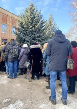 A group, a queue of people with handcarts in the cold season. Stock Photos